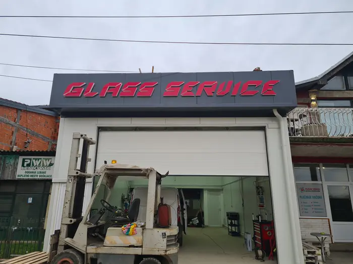 3D slova Glass Service na fasadi tokom dana